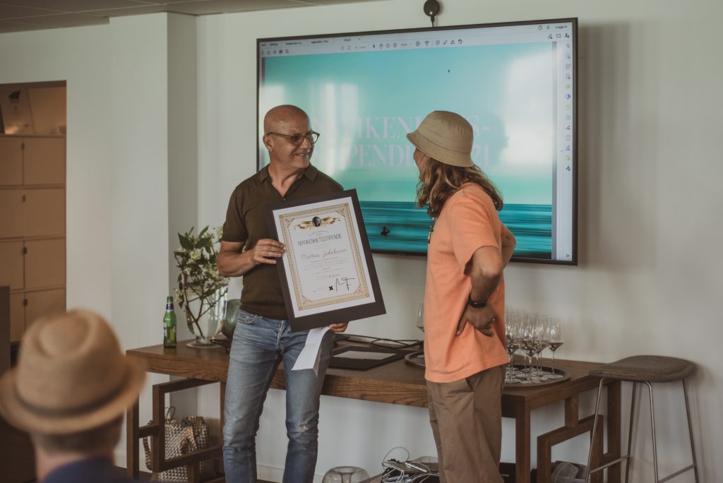 En kille får ett diplom av en annan man